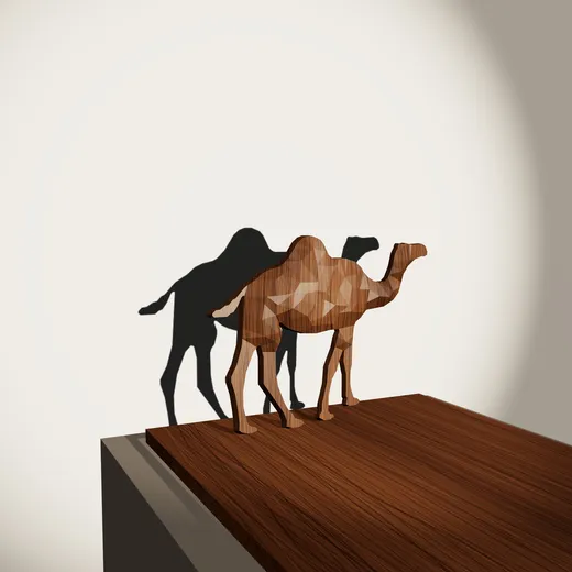 مجسم الجمل من خشب الجوز وظلّه على الحائط